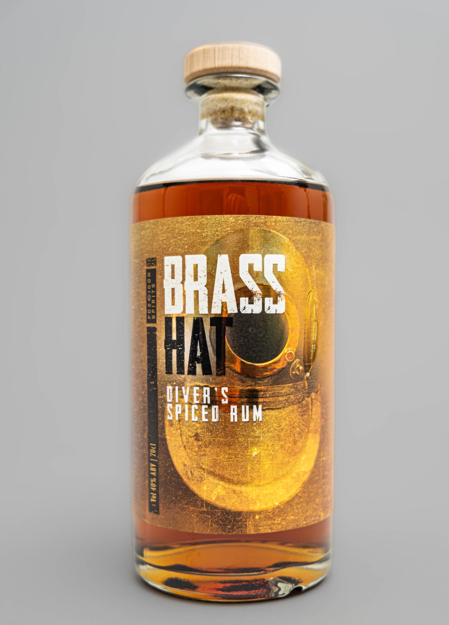 Close up shot of a bottle of Brass Hat Diver's spiced rum with a gold label showing a picture of a deep sea diver's siebe Gorman helmet wooden cork