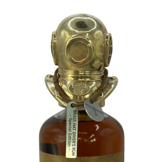 Close up of the Special Edition Diver's Helmet Brass Bottle Topper, complete with identification tag, sitting on top of a bottle of Brass Hat Rum. Perfect collectors edition Diver's Gift
