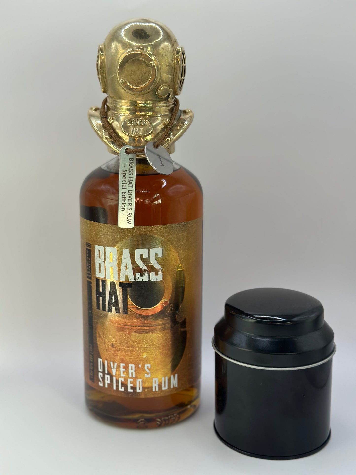Image of the Special Edition Diver's Helmet Brass Bottle Toppersitting on top of a bottle of Brass Hat Diver's Spices Rum. Complete with metal numbered identification tag and presentation tin. Perfect collectors edition Diver's Gift