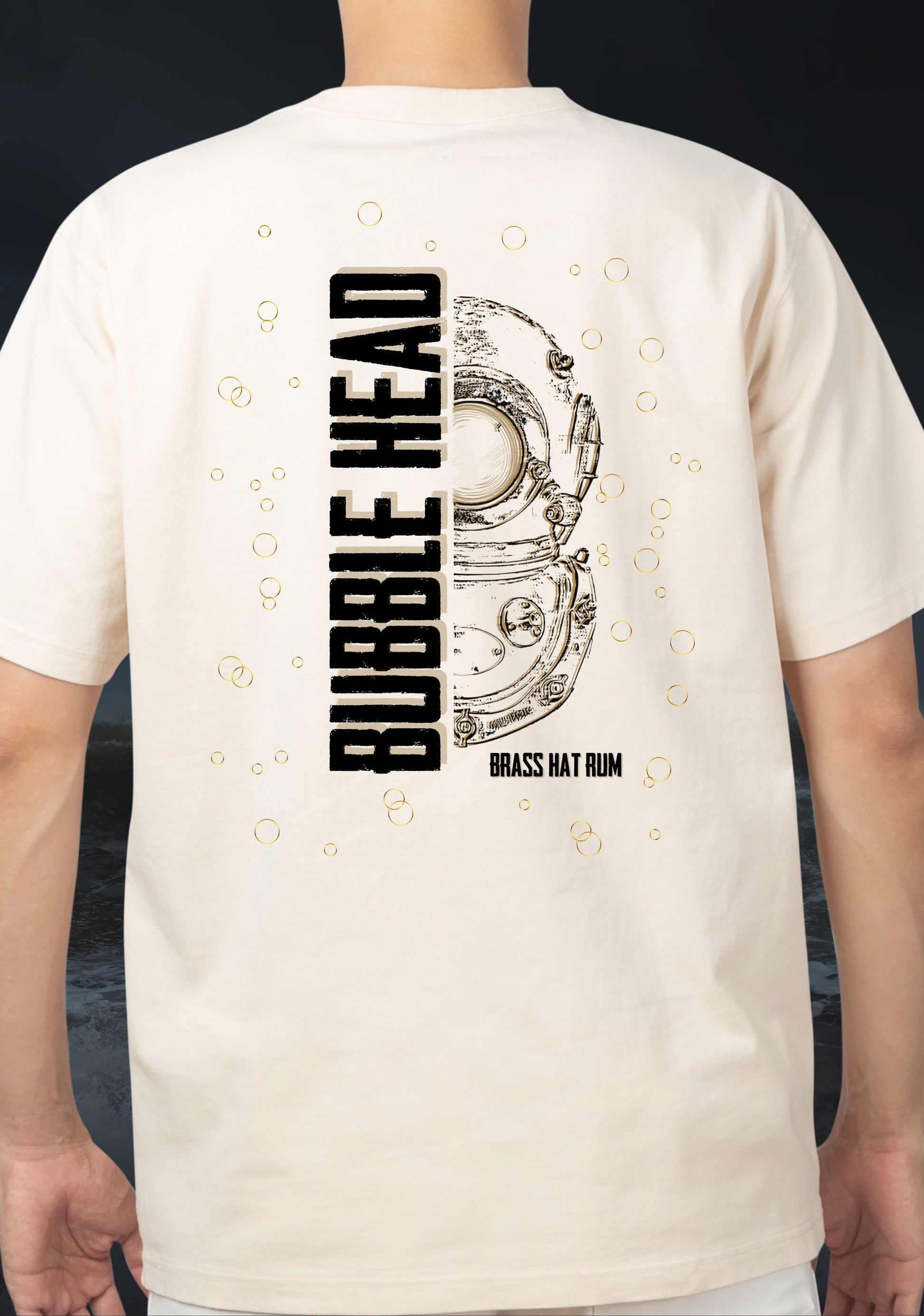 Person wearing a white t-shirt with 'Bubble Head' and 'Brass Hat Rum' design on the back featuring a Siebe Gorman diver's helmet, all set against a dark and stormy seascape background