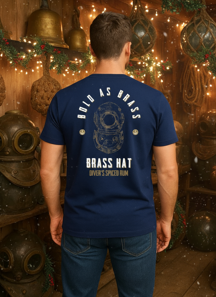 Back view of person wearing Navy Blue Bold As Brass T-shirt in a restive room filled with vintage diving equipment fairy lights and holly. Large diving helmet design with Bold as Brass & Brass Hat Rum branding & anchor motifs. - divers’ Christmas gifts and ocean-inspired apparel