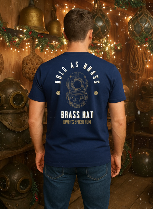 Back view of person wearing Navy Blue Bold As Brass T-shirt in a restive room filled with vintage diving equipment fairy lights and holly. Large diving helmet design with Bold as Brass & Brass Hat Rum branding & anchor motifs. - divers’ Christmas gifts and ocean-inspired apparel