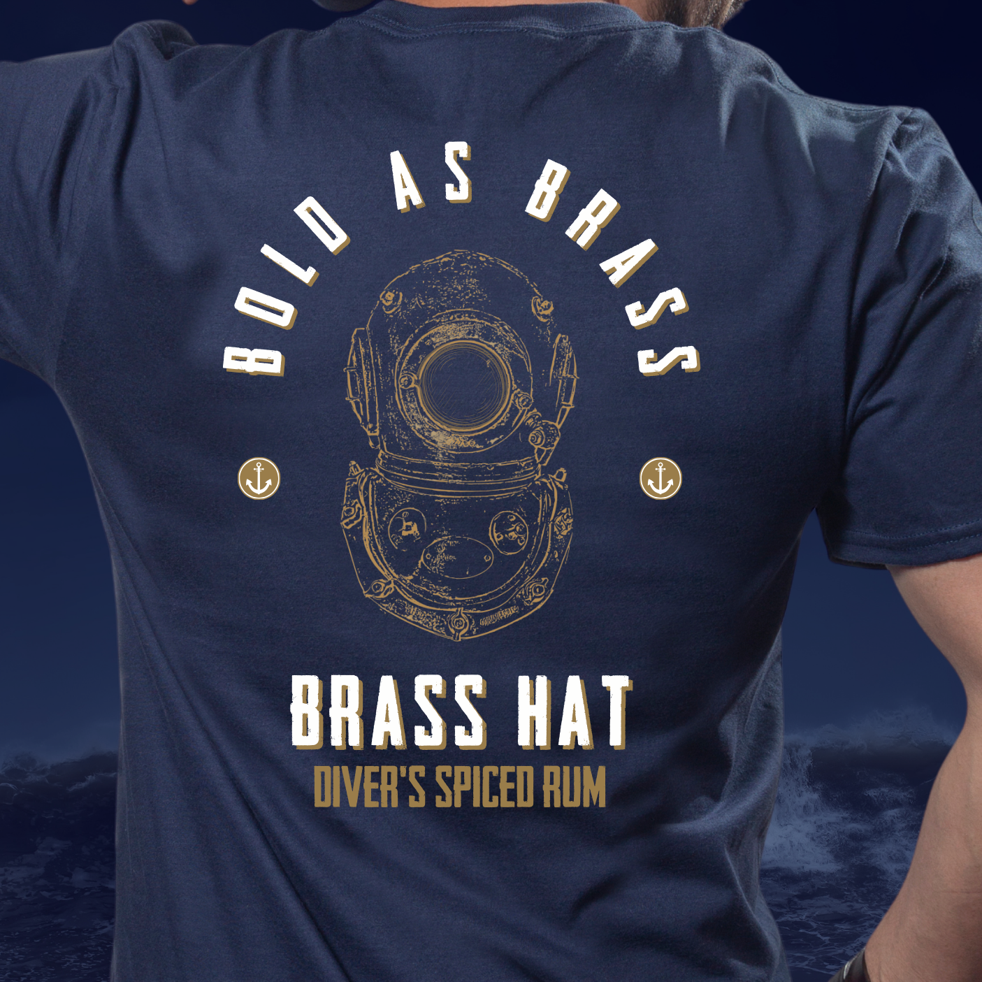 Back view of person wearing Bold As Brass T-shirt in navy blue. Large diving helmet design with Bold as Brass & Brass Hat Rum branding & anchor motifs. - divers’ gifts and ocean-inspired apparel